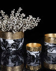 Decorative vases with gold accents and marble patterns on a black background
