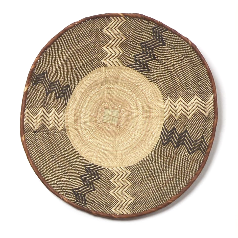 A large, round, handcrafted basket featuring a geometric herringbone pattern in beige and brown tones