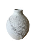 Textured white ceramic vase on a white background