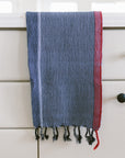 Blue and red striped towel hanging on a white cabinet with black knobs.