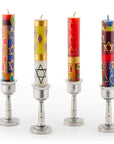 Four colorful candles with star designs in metal candle holders on a white background