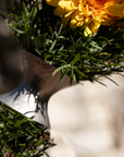 Close-up of a bouquet with yellow flowers and green leaves on a blurred background