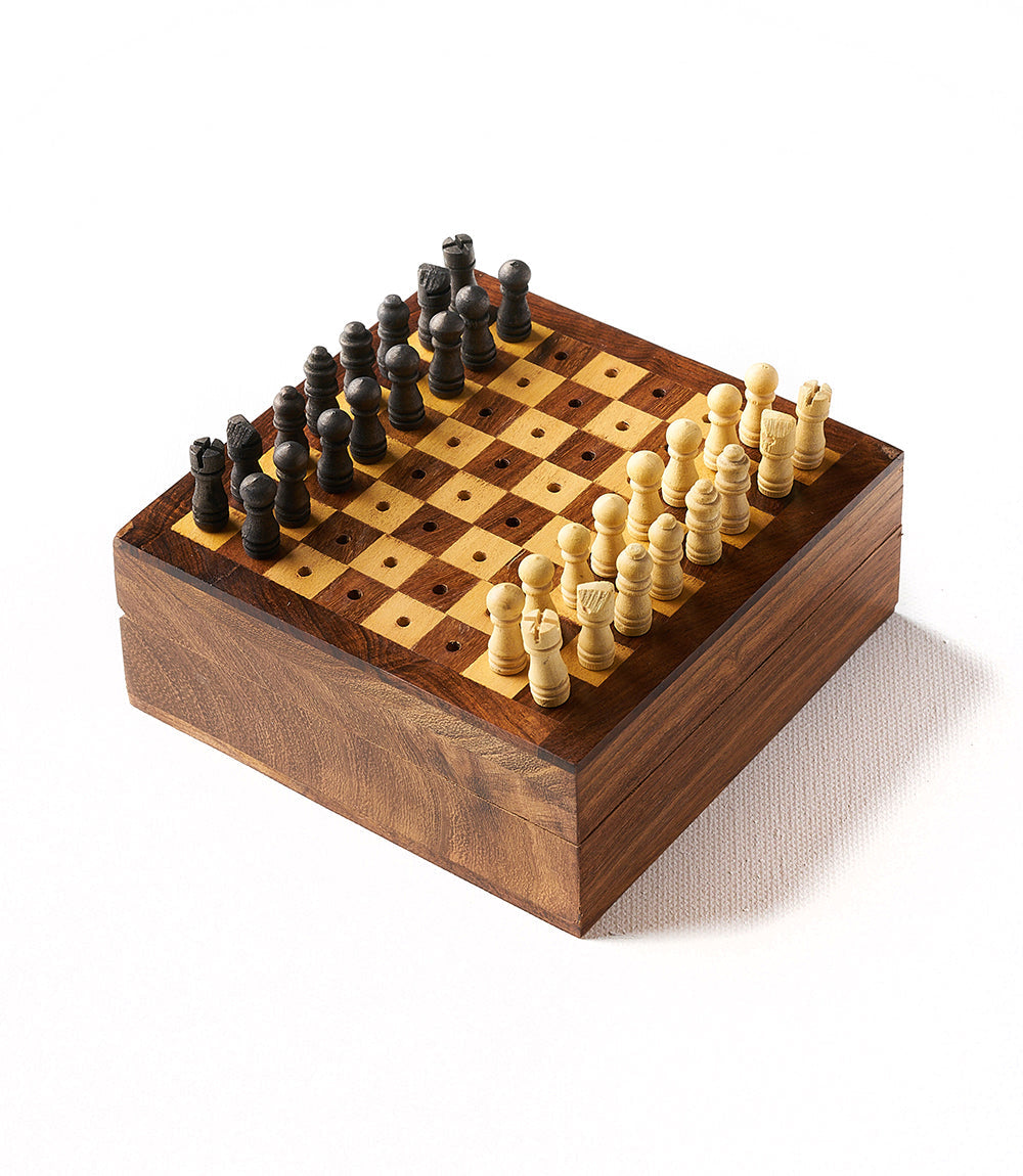 A portable wooden chess game with pieces carved from Indian rosewood, displayed on a white and brown checkered board.