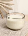 Glass candle on a textured surface with a blurred background