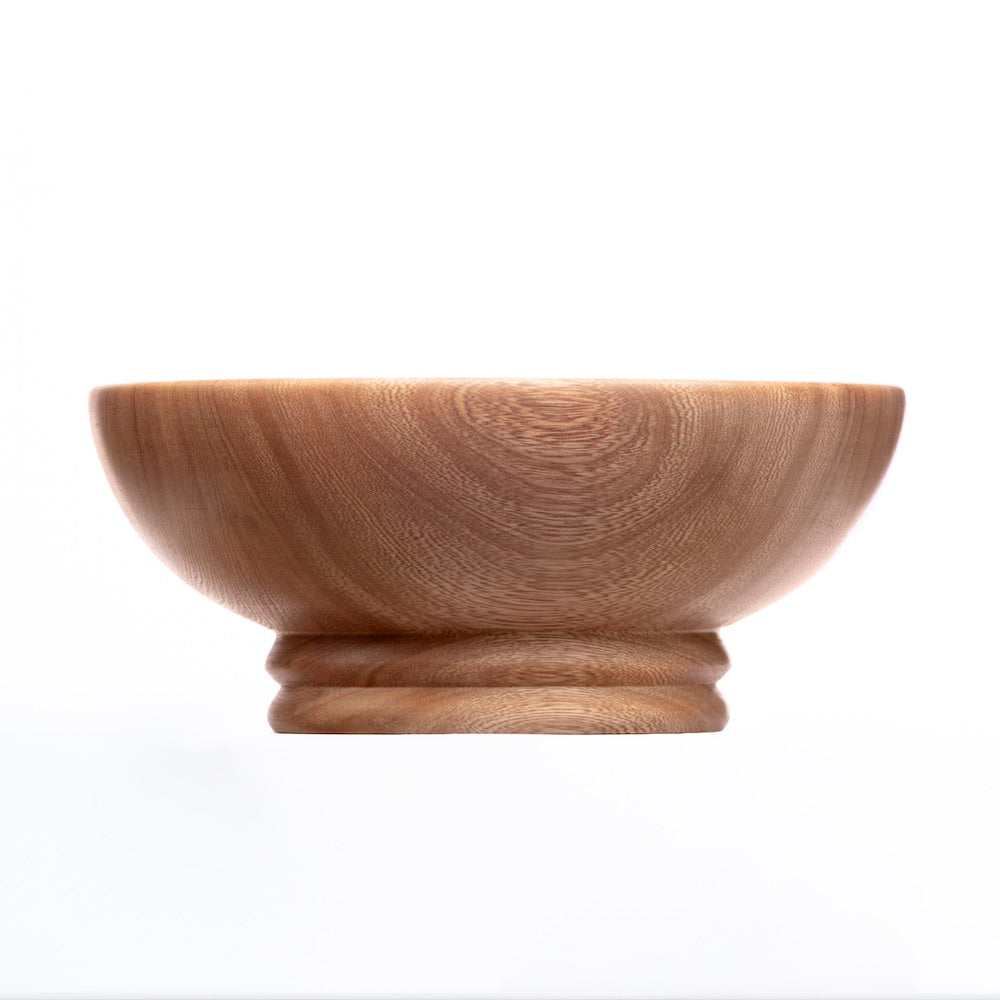 A medium-sized, round wooden bowl with a visible grain pattern, displayed against a plain background.