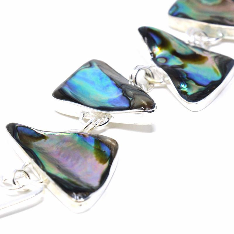 Zoomed in link bracelet with silver-plated triangles and abalone inlays, featuring a hook and link closure.