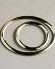 Set of three gold rings on a beige background