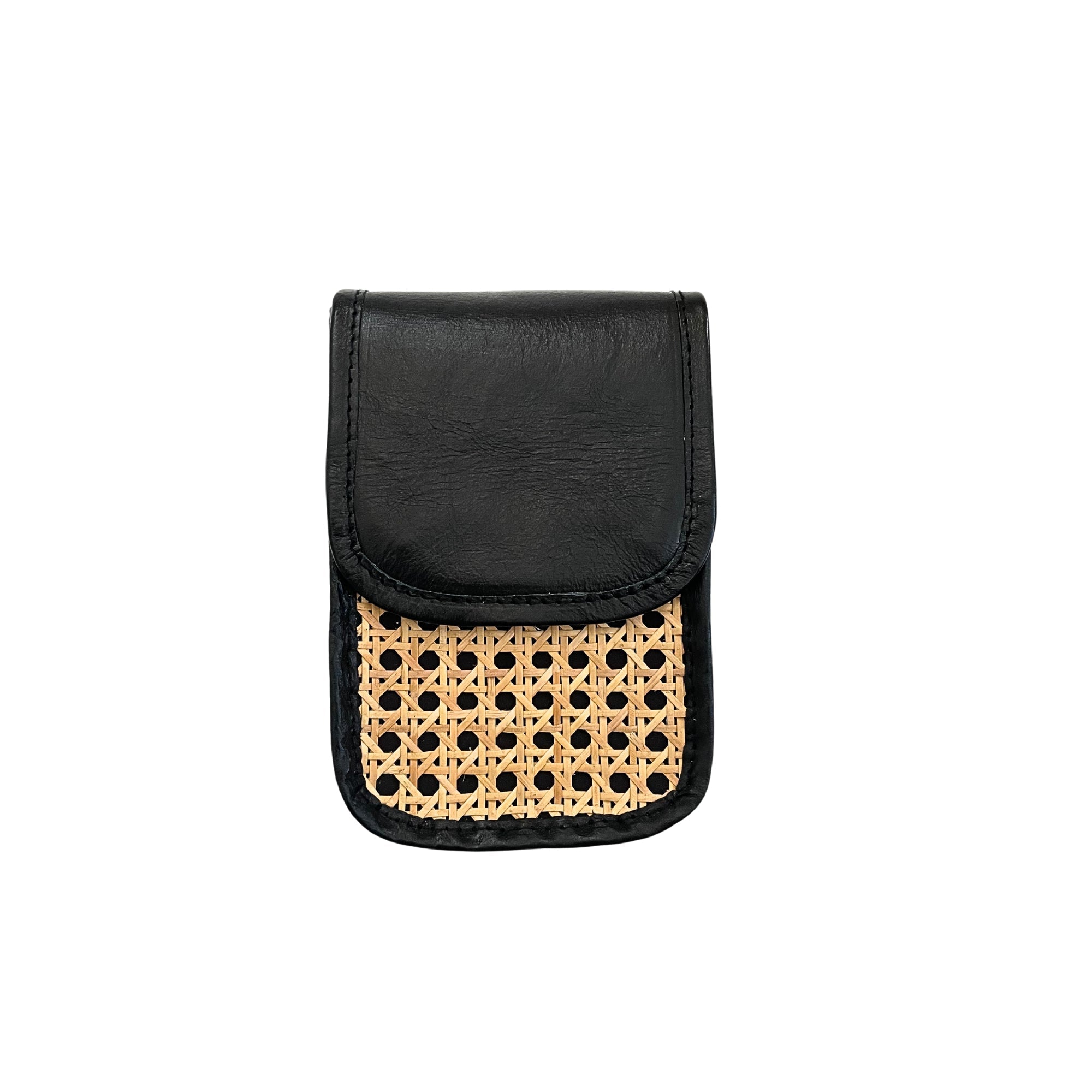 A black clutch crossbody bag with rattan cane pattern on the front and leather trim without the detachable shoulder strap.