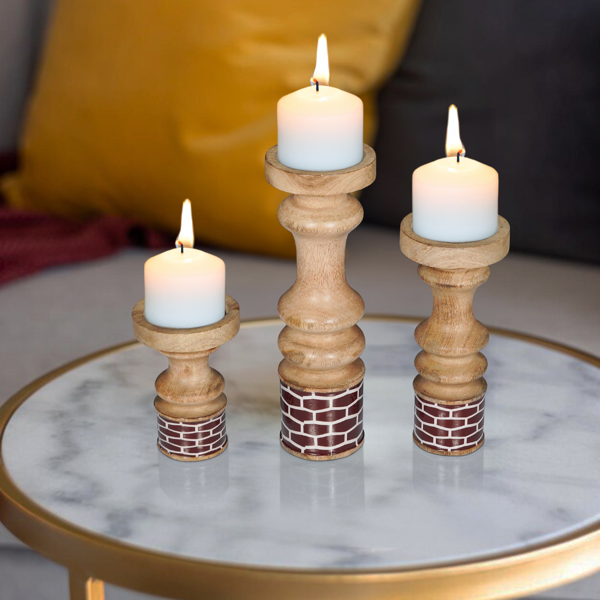 Three wooden candle holders with candles on a marble surface