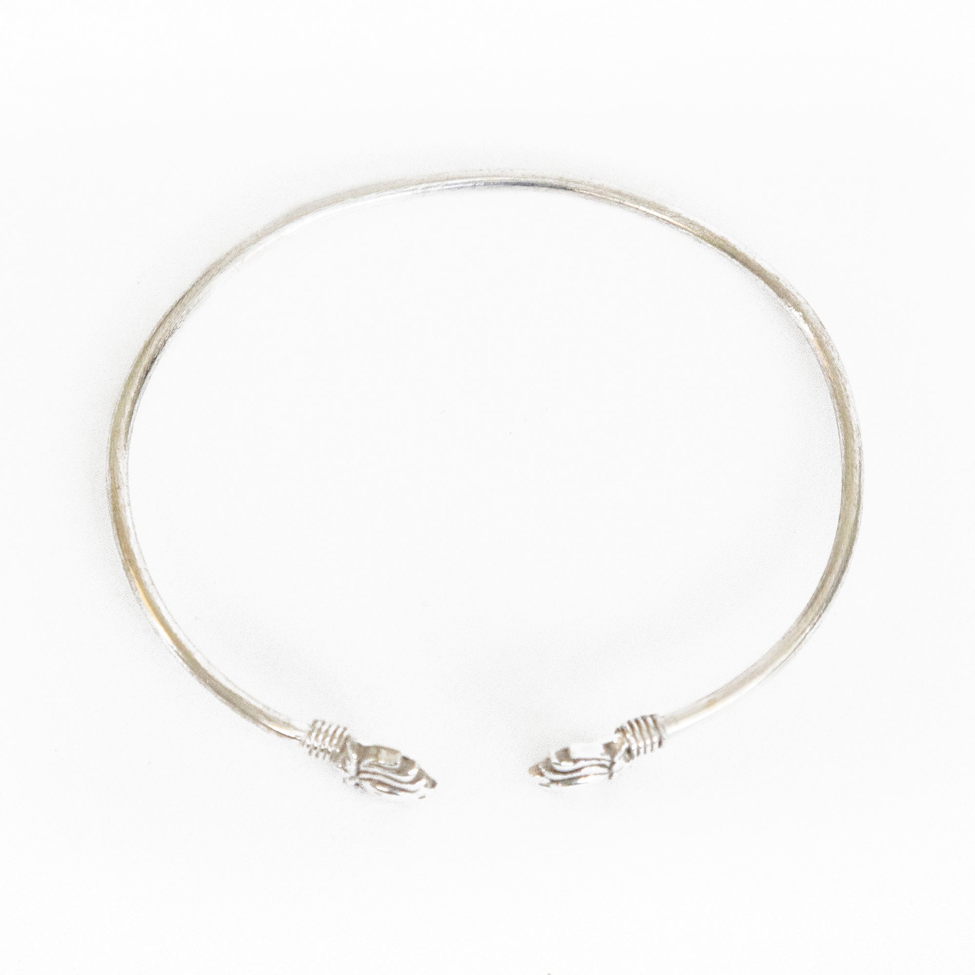 A lotus cuff bracelet with a brass and silver plate finish measuring approximately 1/3 inch. Slightly adjustable size. Interior diameter is approximately 2.5-inches wide.