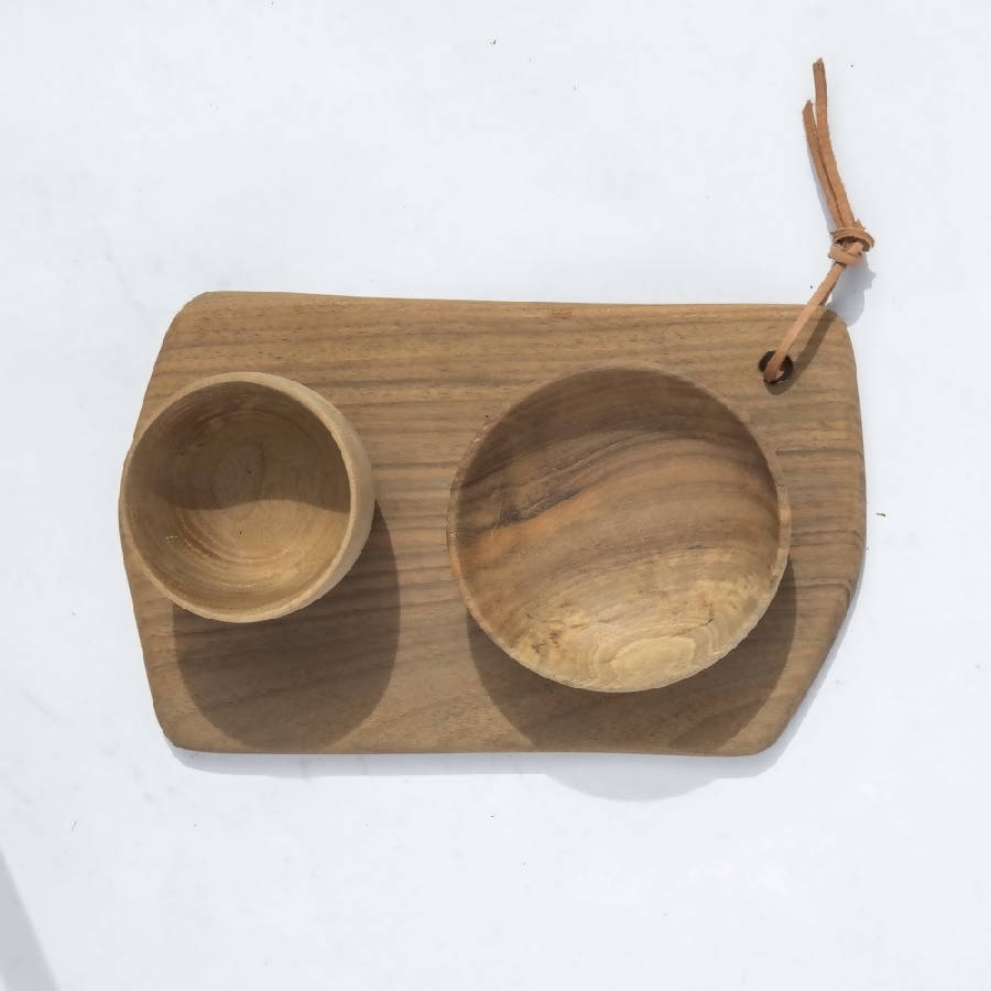 A rectangular walnut wood cutting board with two bowls, placed on a matching walnut wood tray
