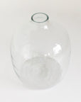 A clear, hand-hammered glass vase with a round shape and a visible textured surface.