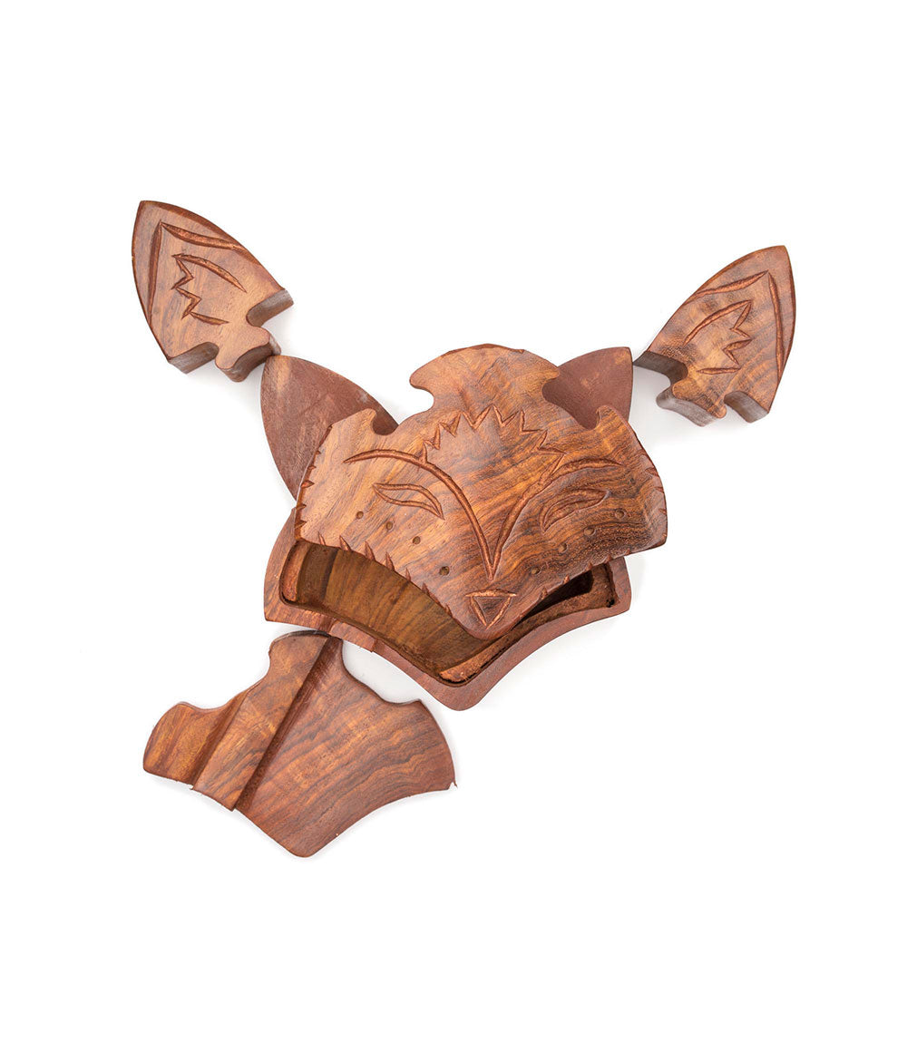 The puzzle pieces of a hand-carved wooden fox face puzzle box.