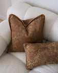 Two brown patterned pillows on a beige sofa