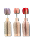 Three decorative tulip-shaped vases made from recycled book paper with colorful tops on a white background