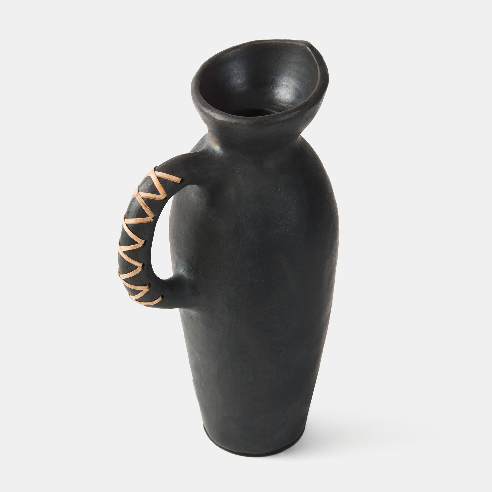 A black clay vase with a geometric pattern on the handle, displayed against a white background