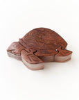 Wooden sea turtle puzzle box put together with a white background.