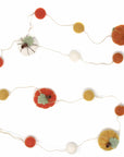 Decorative string with felt pumpkins, flowers, and spider on a white background