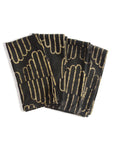 Set of black napkins with gold geometric pattern on a white background