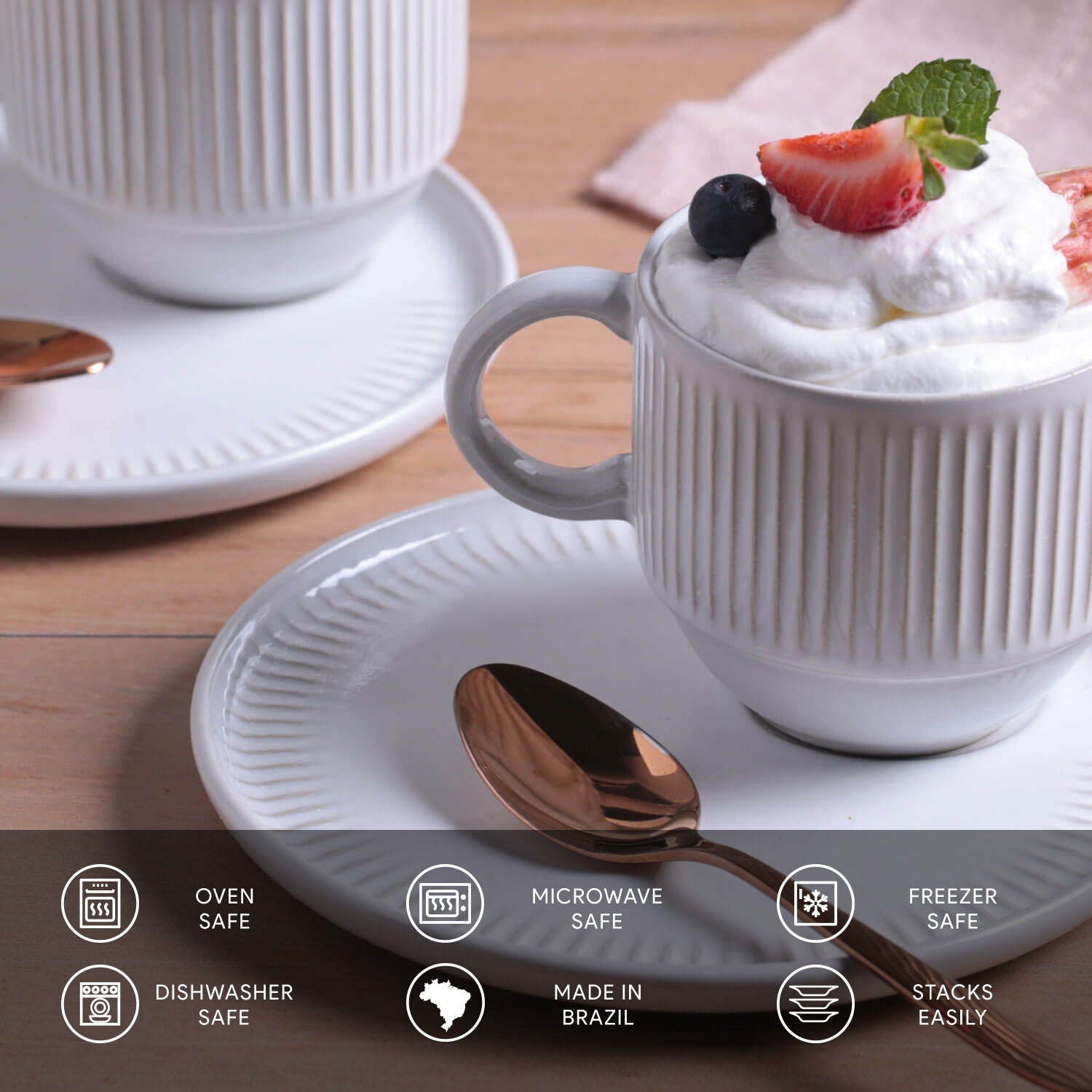 White ceramic mug with dessert on a wooden table, featuring oven, microwave, and dishwasher safety icons