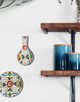 A multicolored, handmade pottery spoon rest hanging on a wall