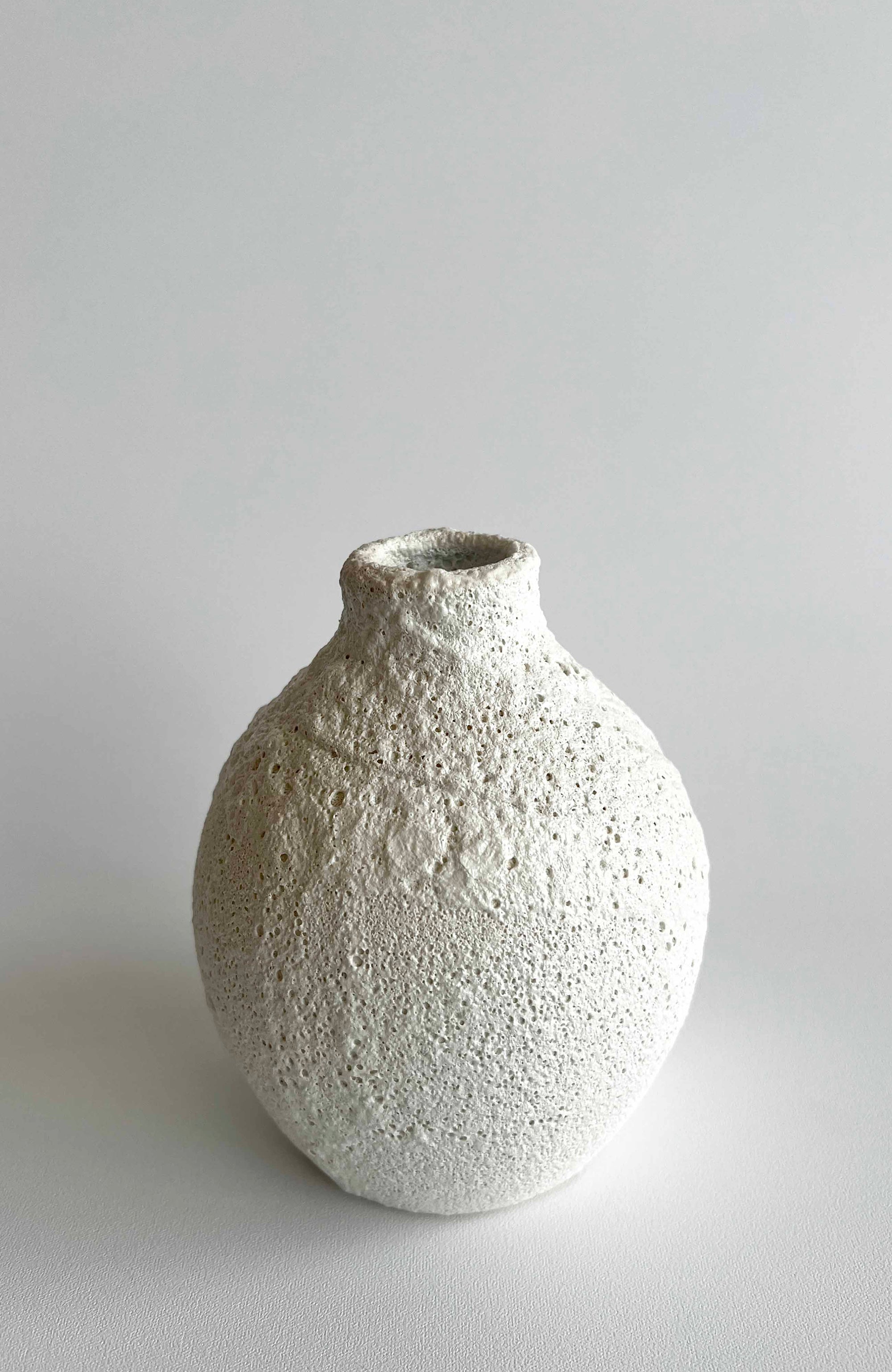 Textured ceramic vase on a light gray background