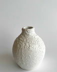 Textured ceramic vase on a light gray background
