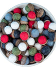Colorful felt acorn ornaments in a white bowl on a white background