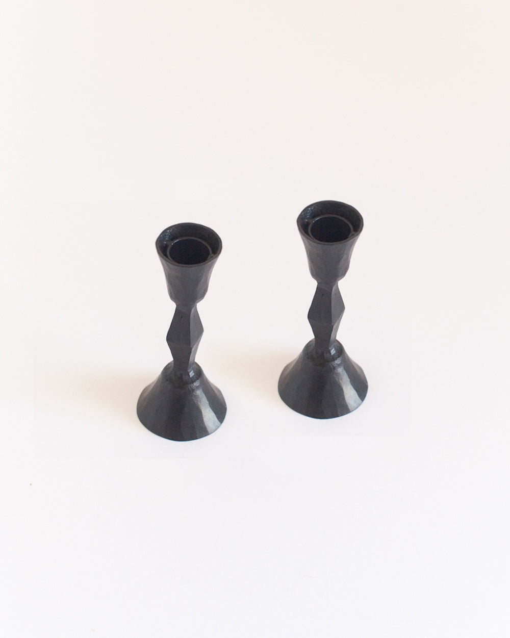 Two black candle holders on a white background