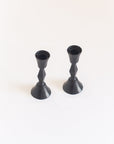 Two black candle holders on a white background