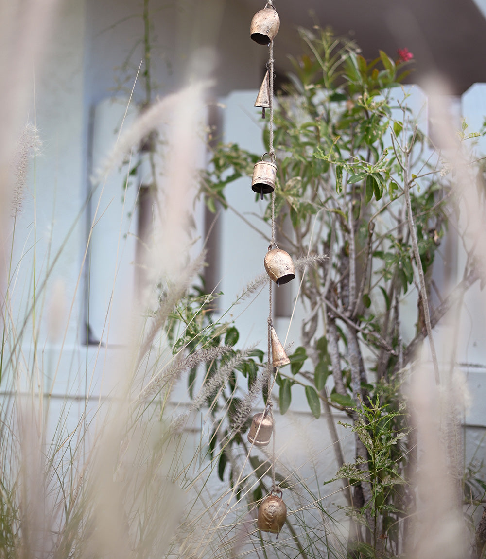 A gold rustic garland with bells hanging outside