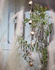 A gold rustic garland with bells hanging outside