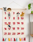 A hanging wool advent calendar with little animals popping out of the days