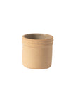 A beige ceramic mezcal cup with a rounded shape, showcasing earthy tones and textures