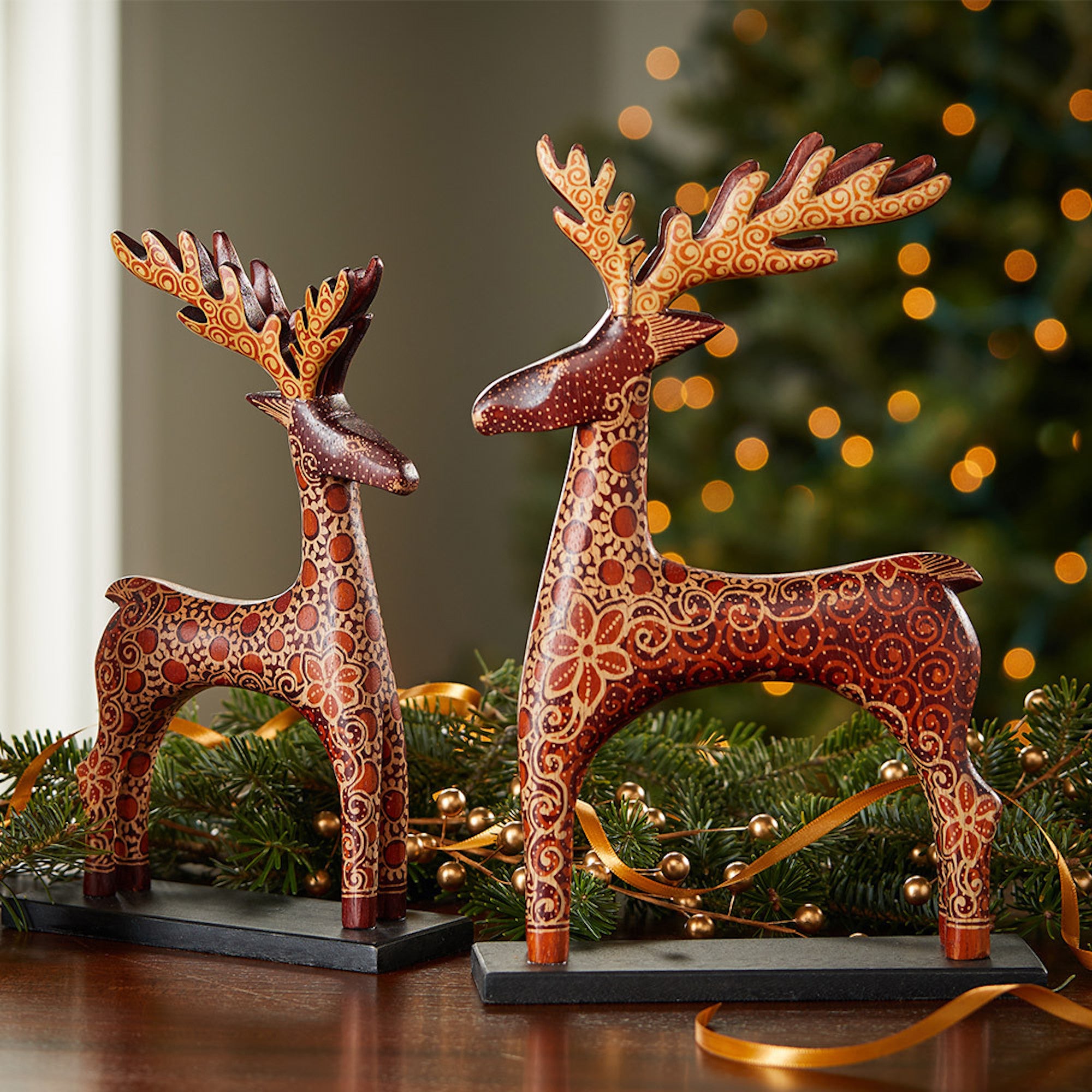 Decorative reindeer figurines on a wooden surface with a festive background.