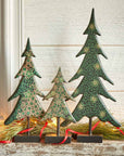 Decorative Christmas trees with green patterns on a wooden surface