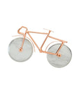 A pizza cutter designed to resemble a bicycle, with a copper-plated frame and silver-colored wheels