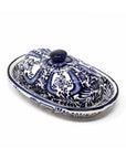 An oval ceramic butter dish with a matching lid, decorated with a blue and white floral pattern, shown on a plain white background.