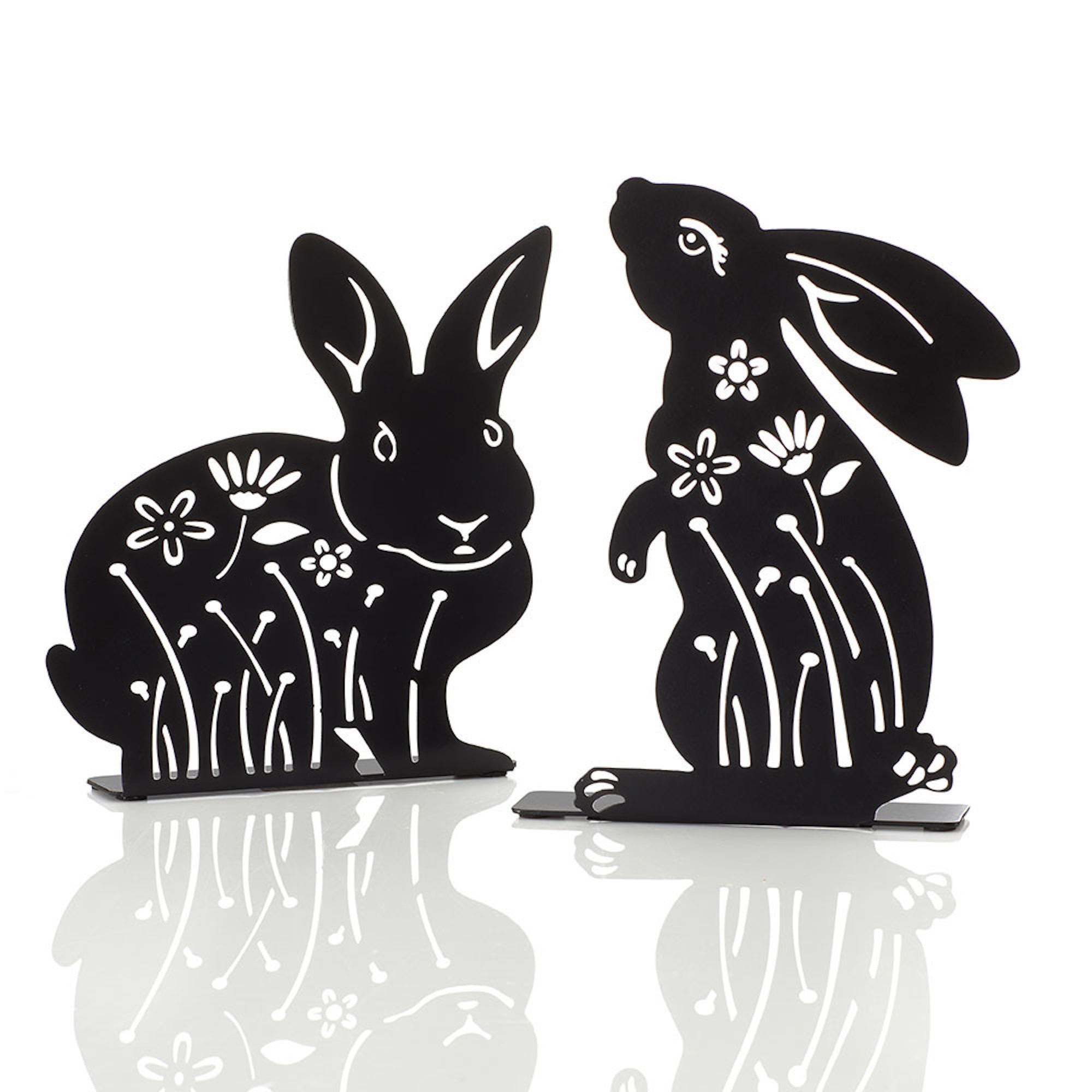 Two metal silhouettes of rabbits with floral designs, one sitting and one standing, against a white background.
