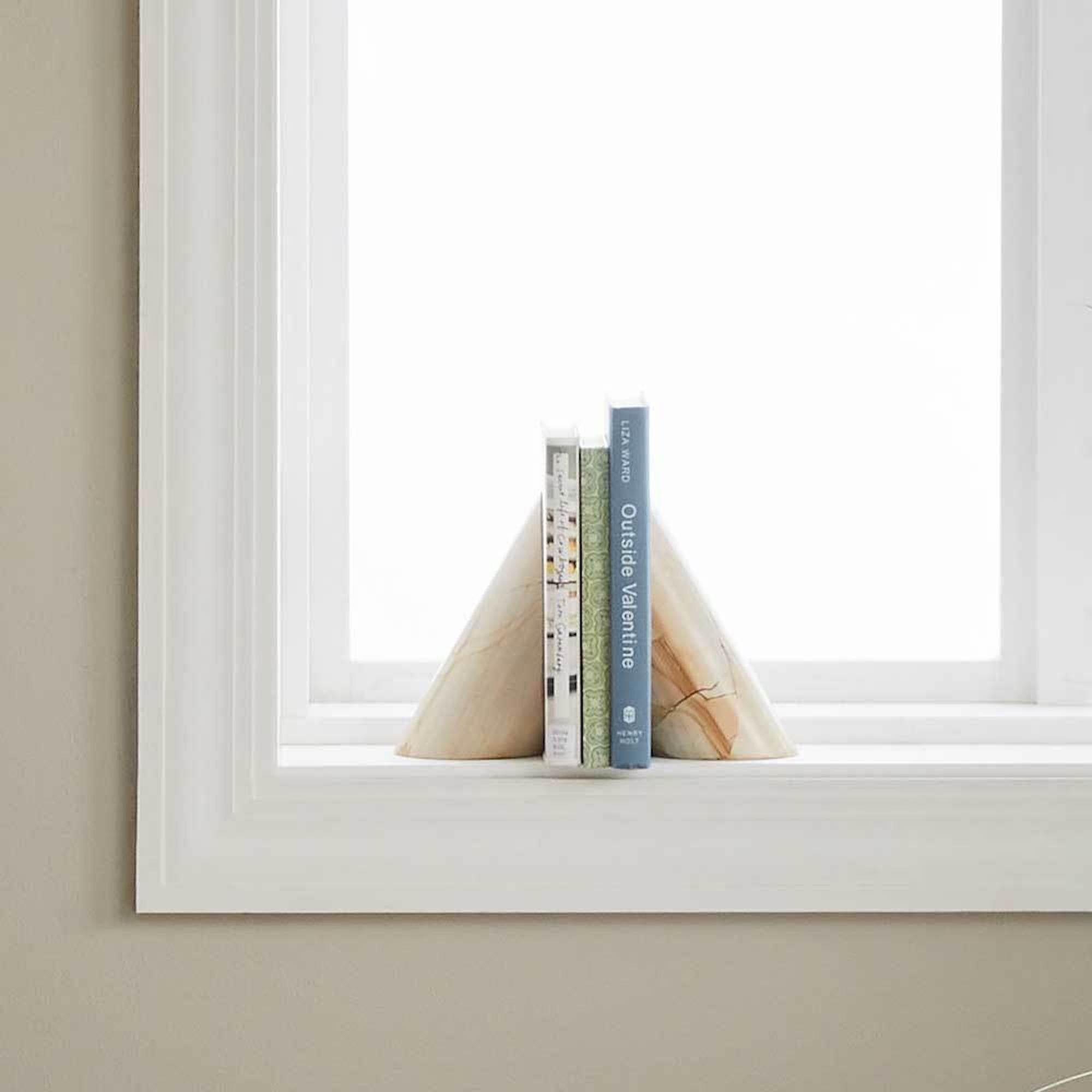 A pair of stone bookends with three books inbetween