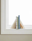 A pair of stone bookends with three books inbetween