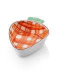 A ceramic serving dish shaped like a carrot with a hand-painted orange plaid pattern and green top.