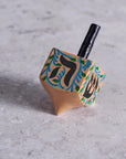 Wooden dreidel with Hebrew letters on a gray surface