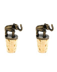 A set of two brass elephant wine bottle stoppers sitting atop corks.