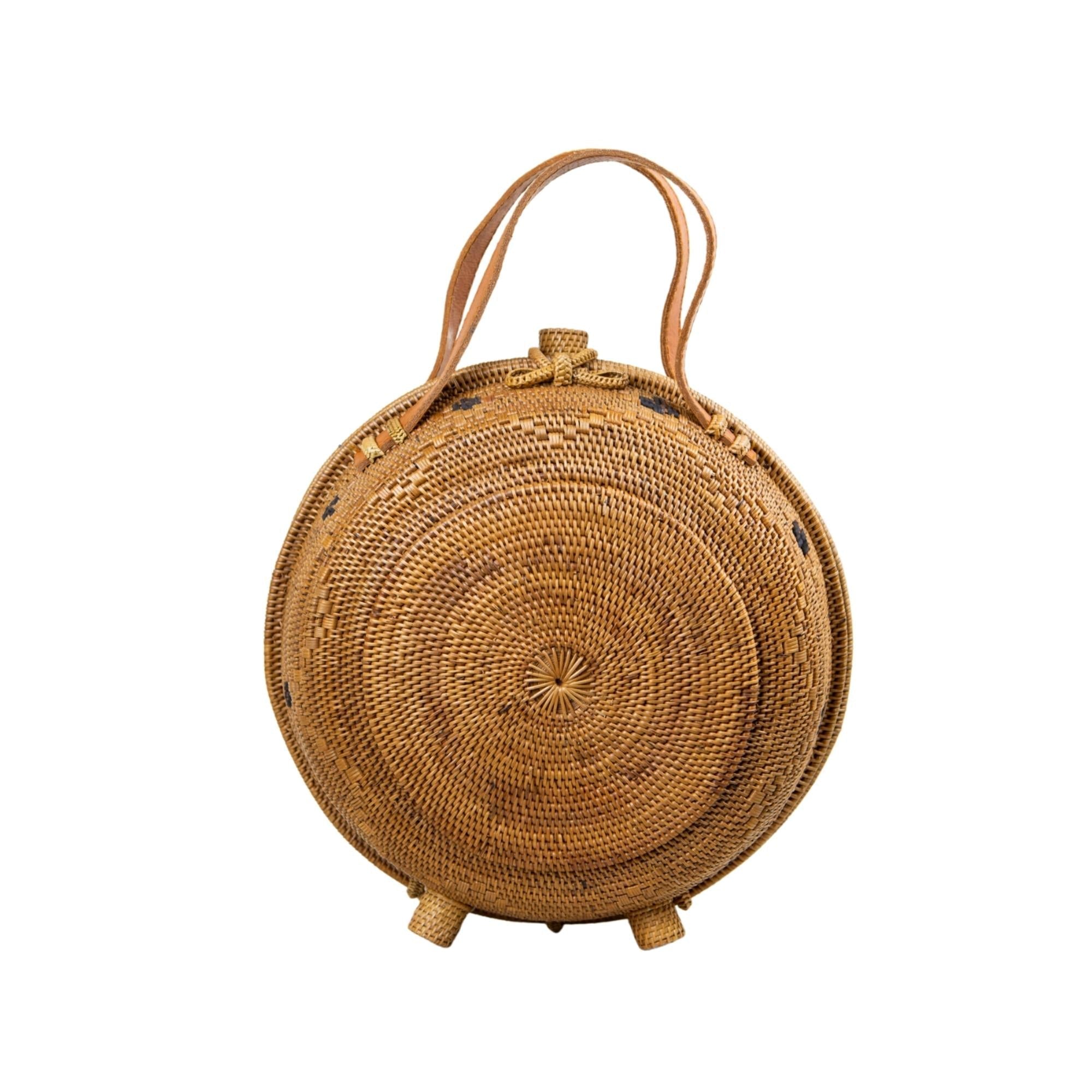 An oversized rattan round satchel with leather handles and a natural brown color with a white background.