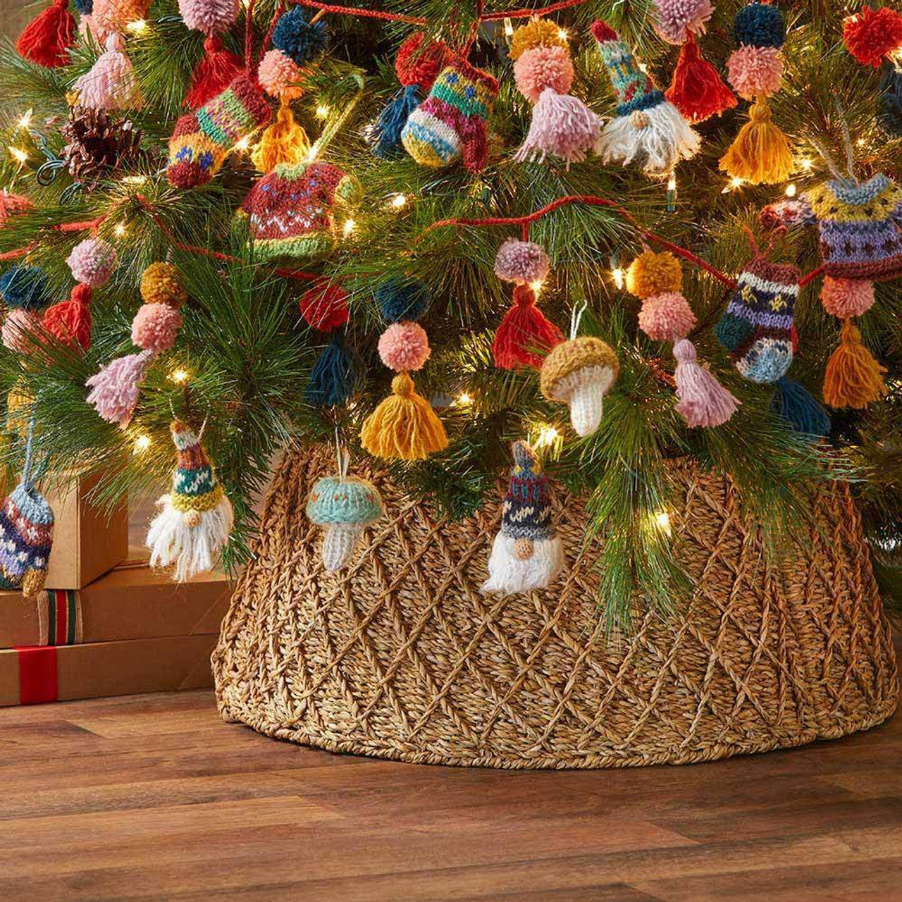 Decorated Christmas tree with colorful knitted garland and a woven base