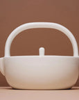A small ceramic teapot made of new bone china