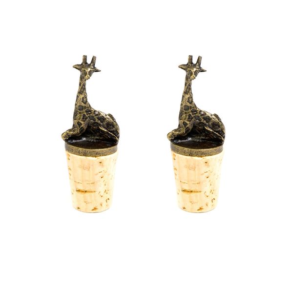 A set of two brass giraffe-shaped wine bottle stoppers sitting atop corks.