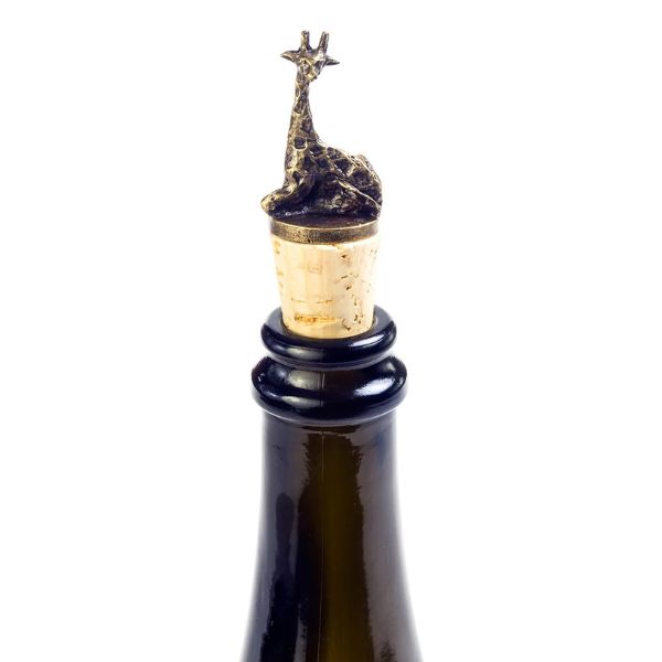 A brass giraffe-shaped wine bottle stoppers sitting atop corks on top of a wine bottle.