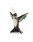 A hand-painted ceramic jewelry holder in the shape of a hummingbird holding rings and earrings.